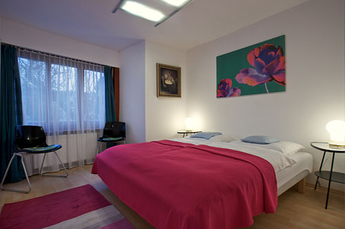 Diagonal view of the main bedroom shows the large window which opens in the private garden of the house. This ensures quiet sleep for the guests.
