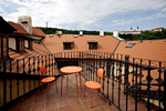 The red roof of the Janska residence is contrasted against the green of Petrin Hill, the white Strahov Monestary and the Prague's blue summer sky. Apartments in Prague offers many wonderful apartments in the Residence Janska. Photo by Pavel Horejsi